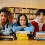 A group of diverse students engaging in studies at a library, surrounded by books and resources.